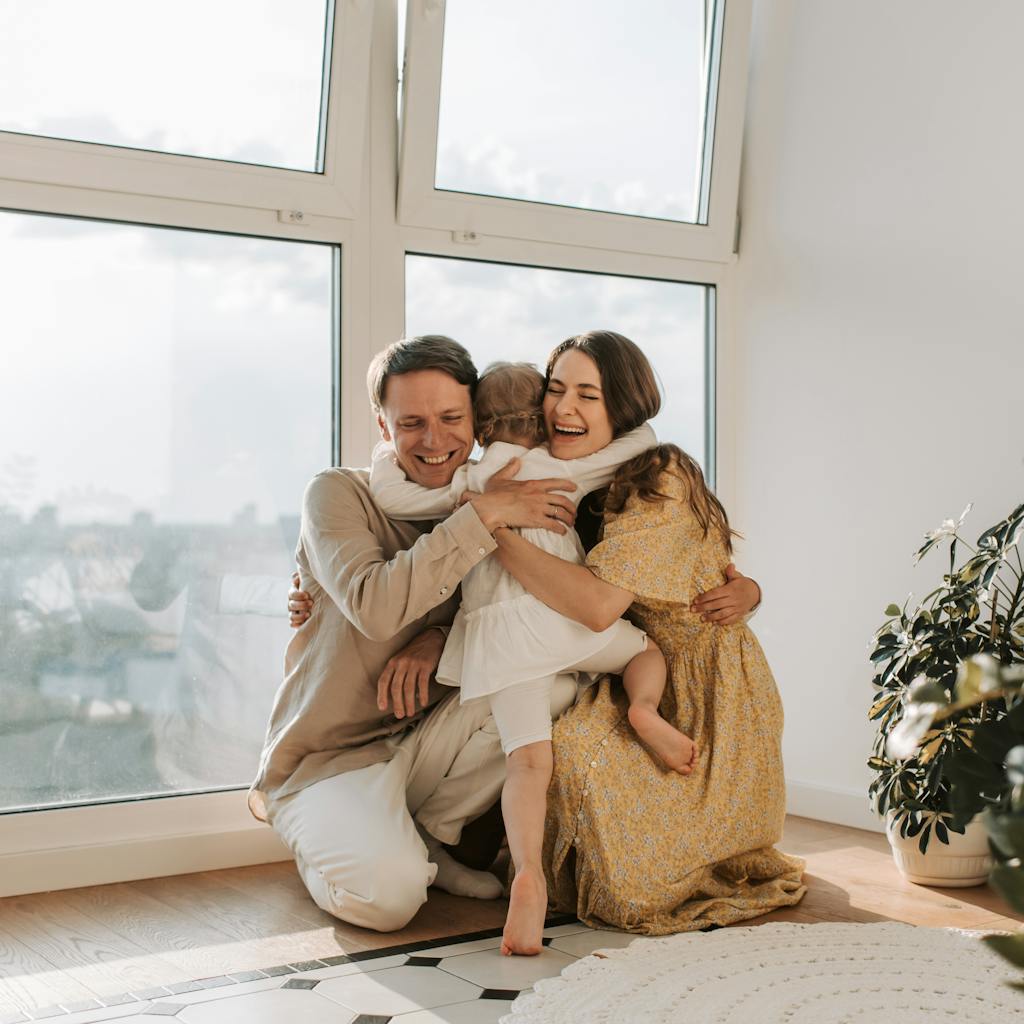 A family hugging tightly near a window. An example of how relationships benefit from responding to disrespect in loving and healthy ways.