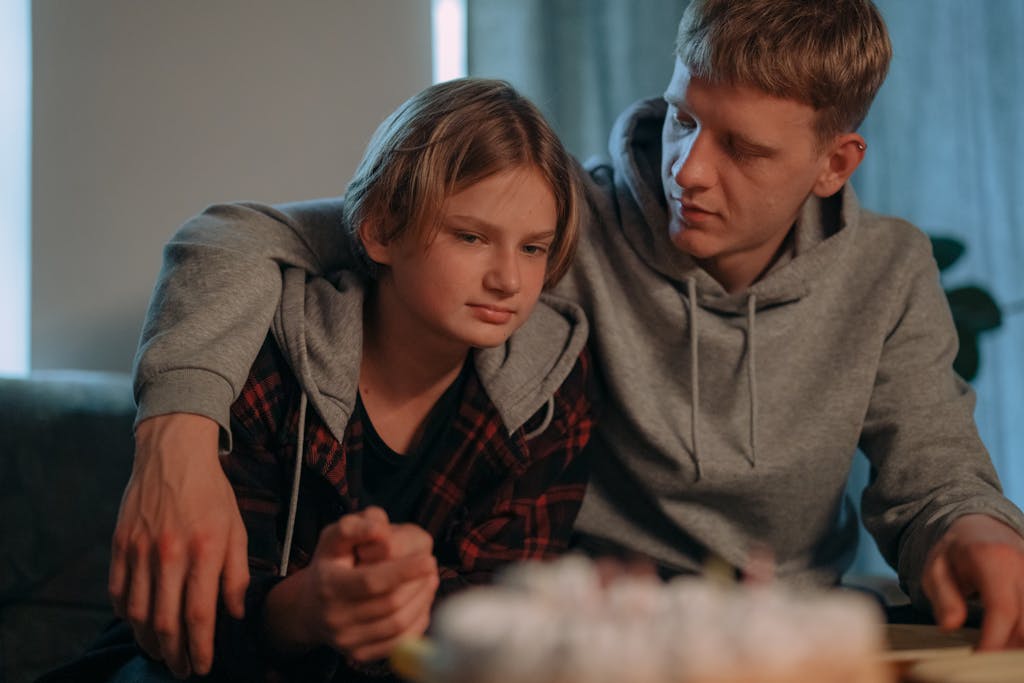 A heartfelt scene of two young adults sharing comfort indoors, enhancing emotional connection.